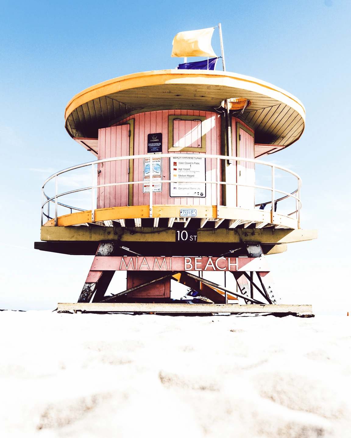 Rosafarbener Rettungsschwimmerturm in Miami Beach mit blasser Instax-Farbe und hellem Sand