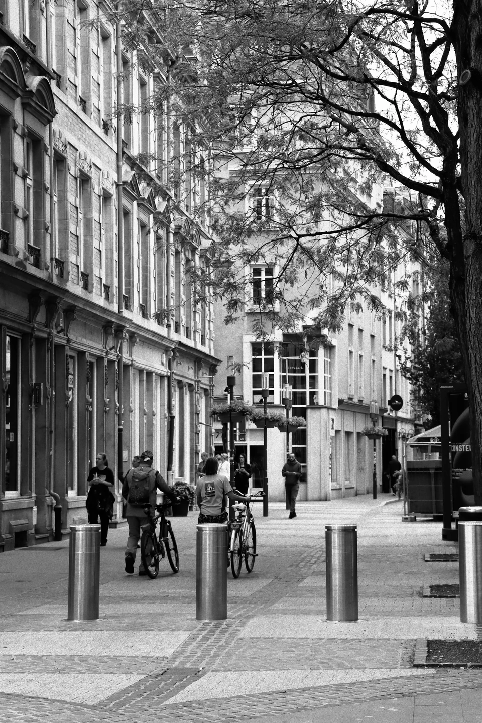 Radfahrer auf einer ruhigen Straße in Schwarzweiß mit sichtbarem Korn
