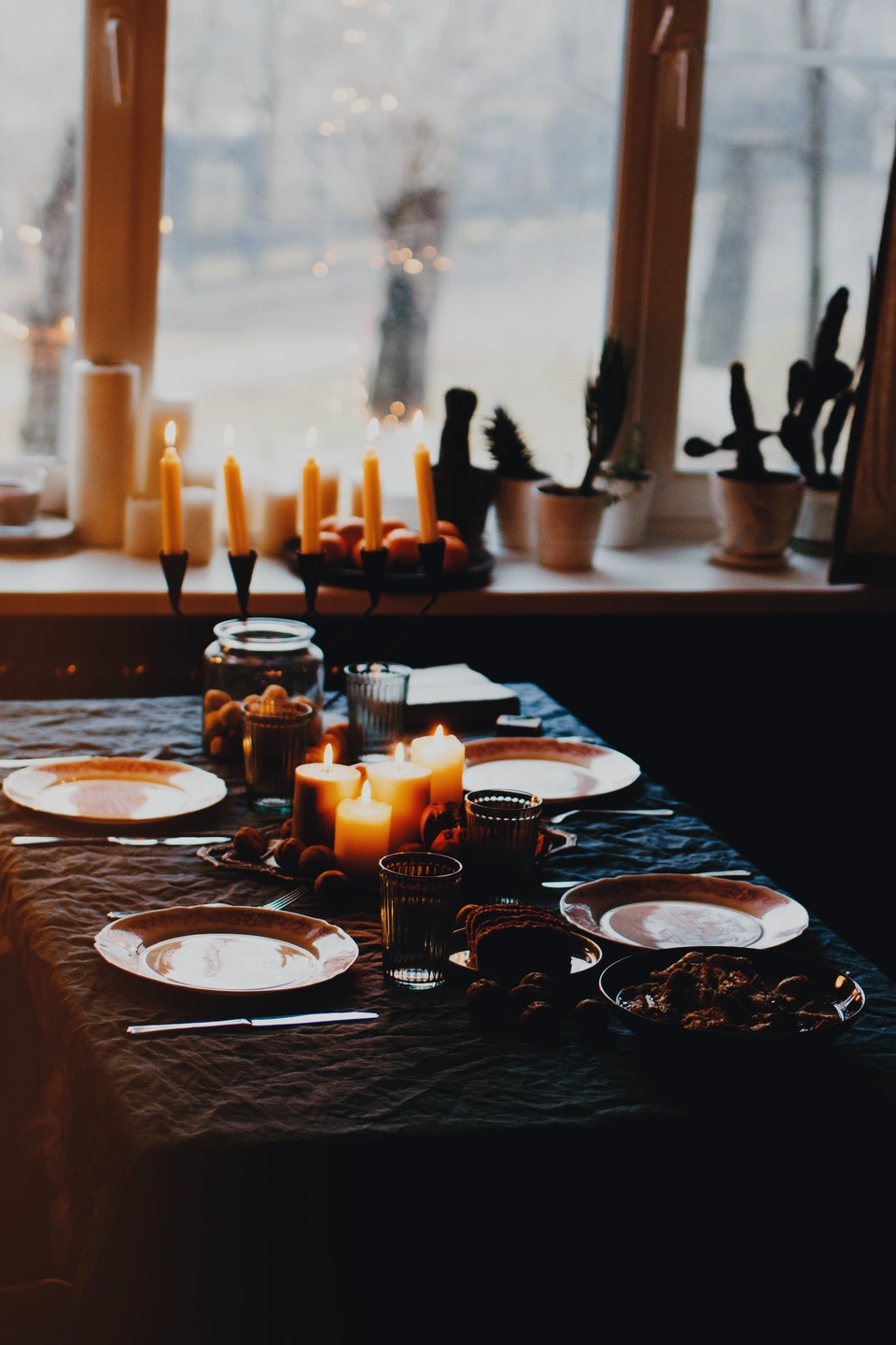 Una mesa oscura a la luz de las velas con una luz cálida en el borde izquierdo