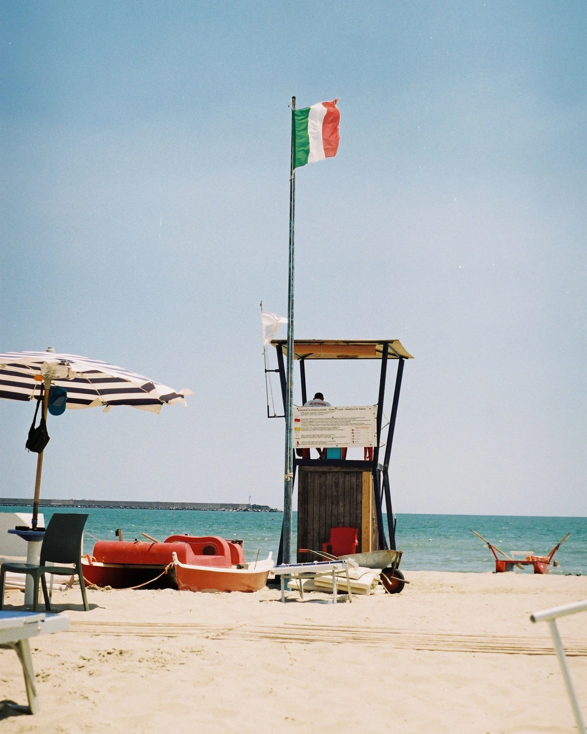 Unframed beach photograph with a red lifeguard boat