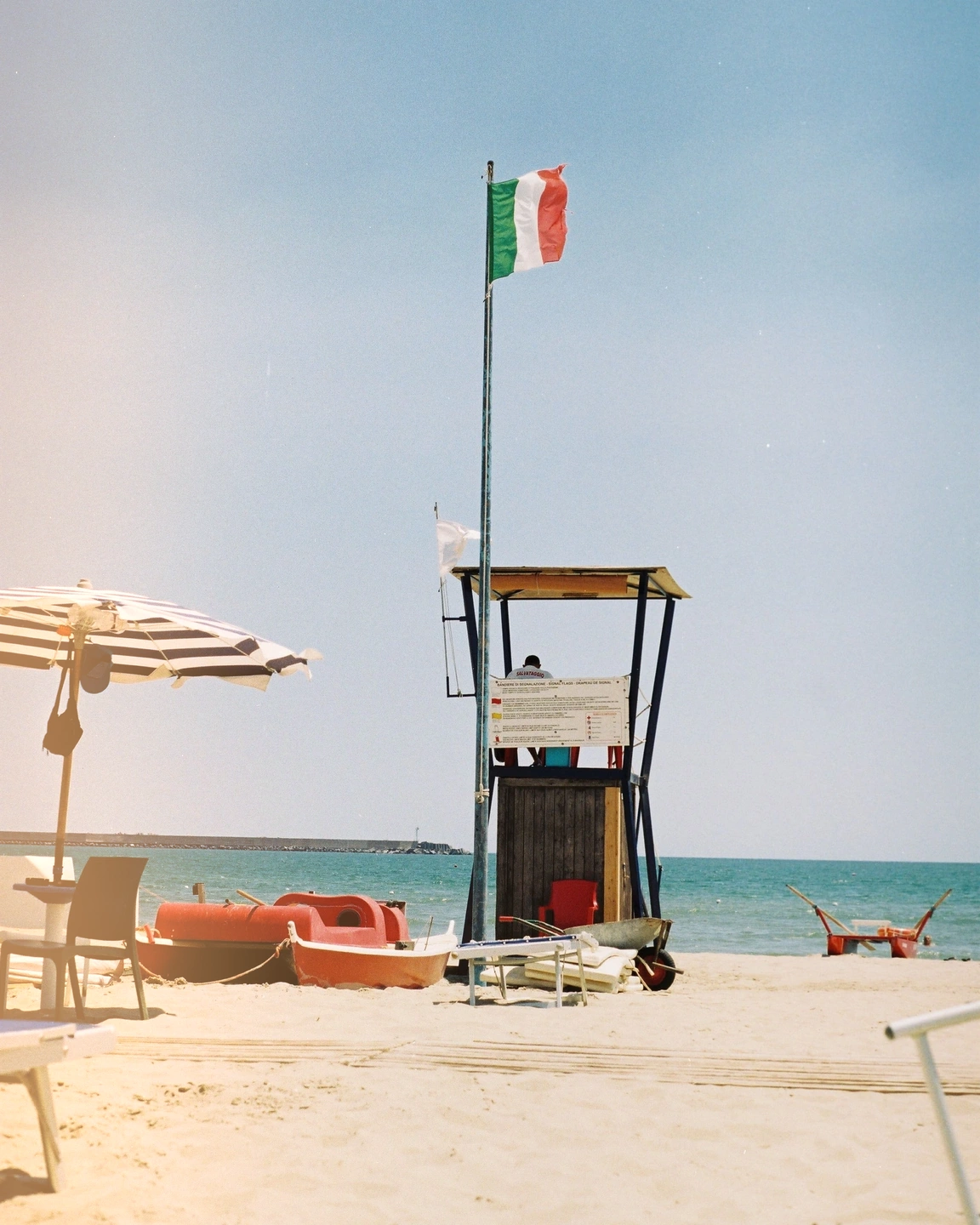 Beach and red boat with a warm light leak entering from the edge