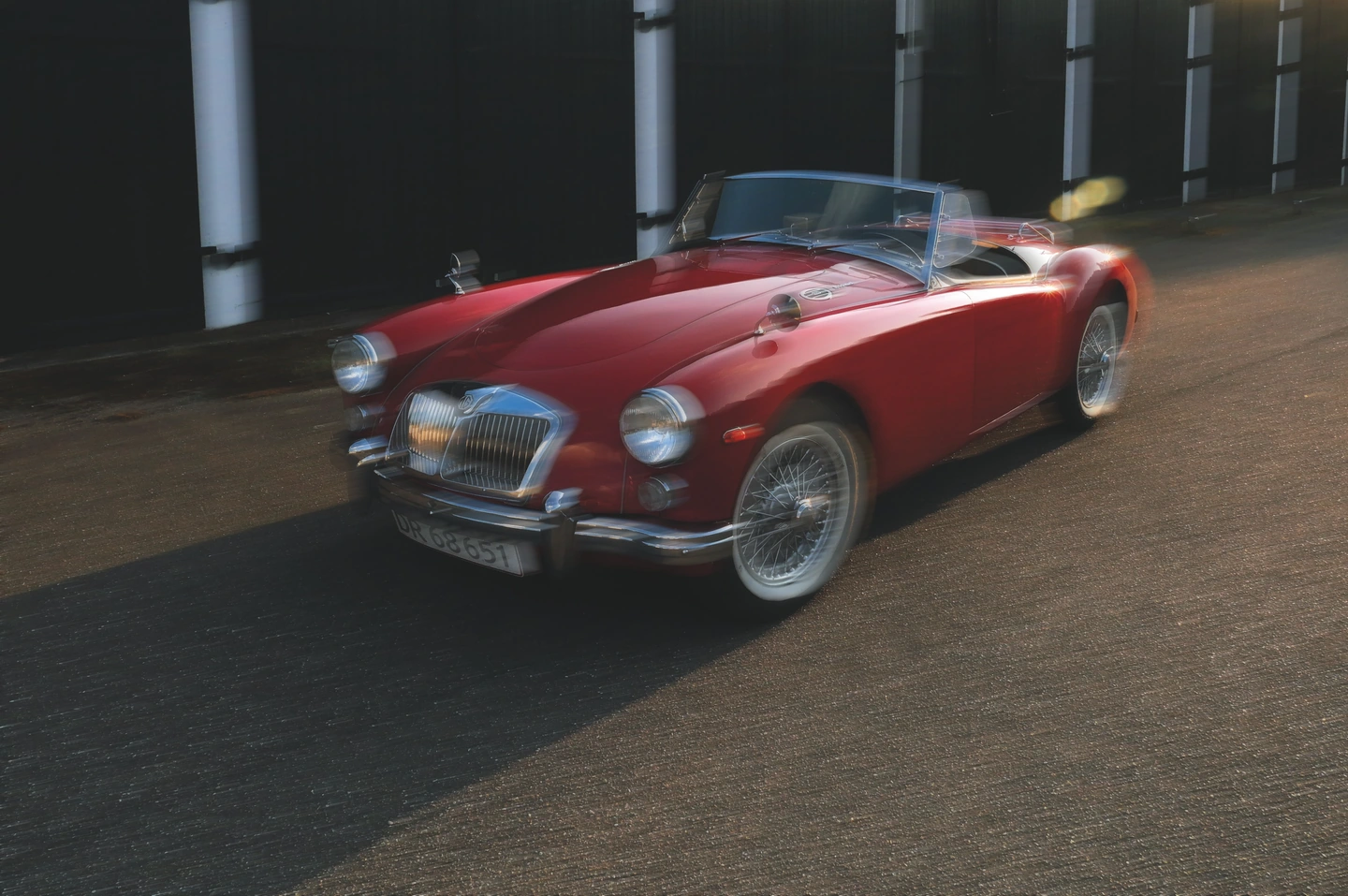 Red vintage roadster with a directional motion-blur treatment