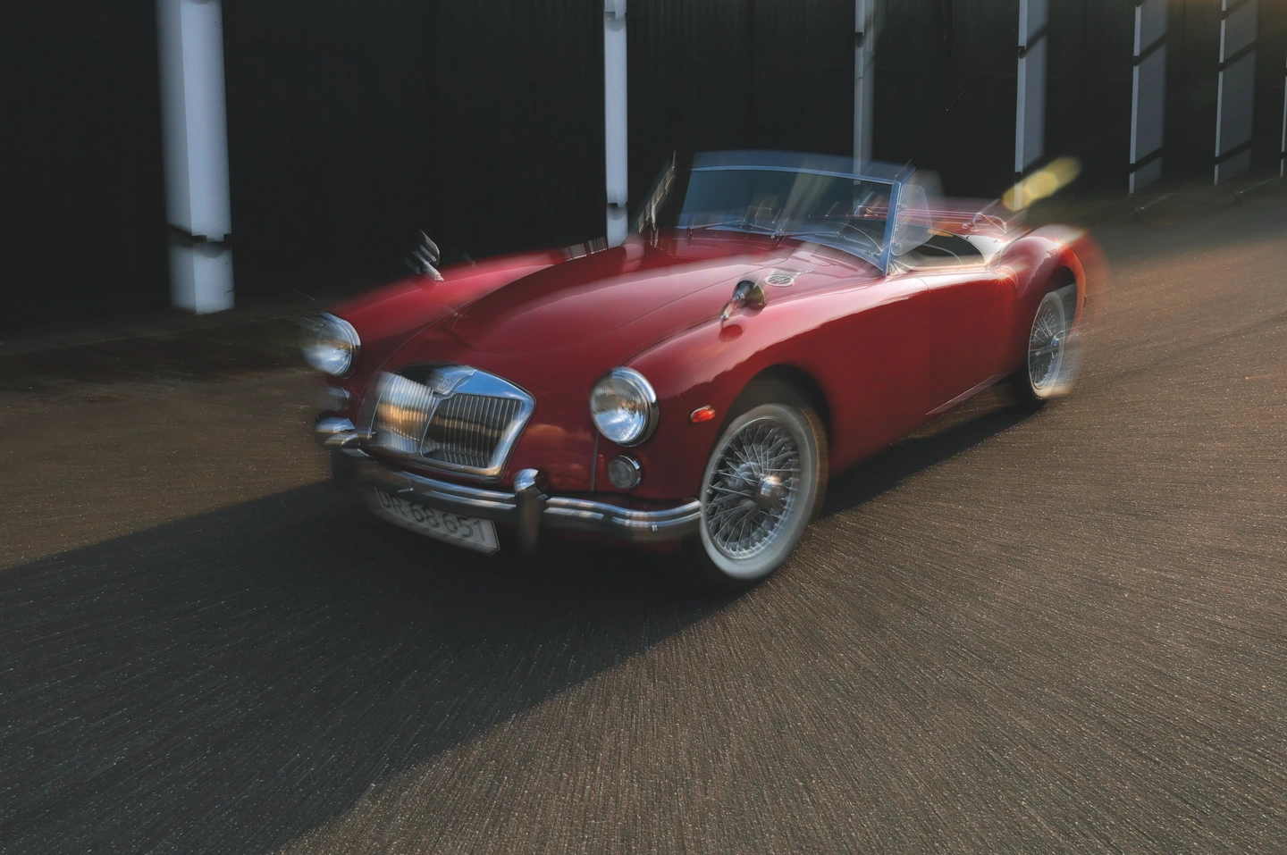 A red roadster with zoom blur radiating into the surrounding street