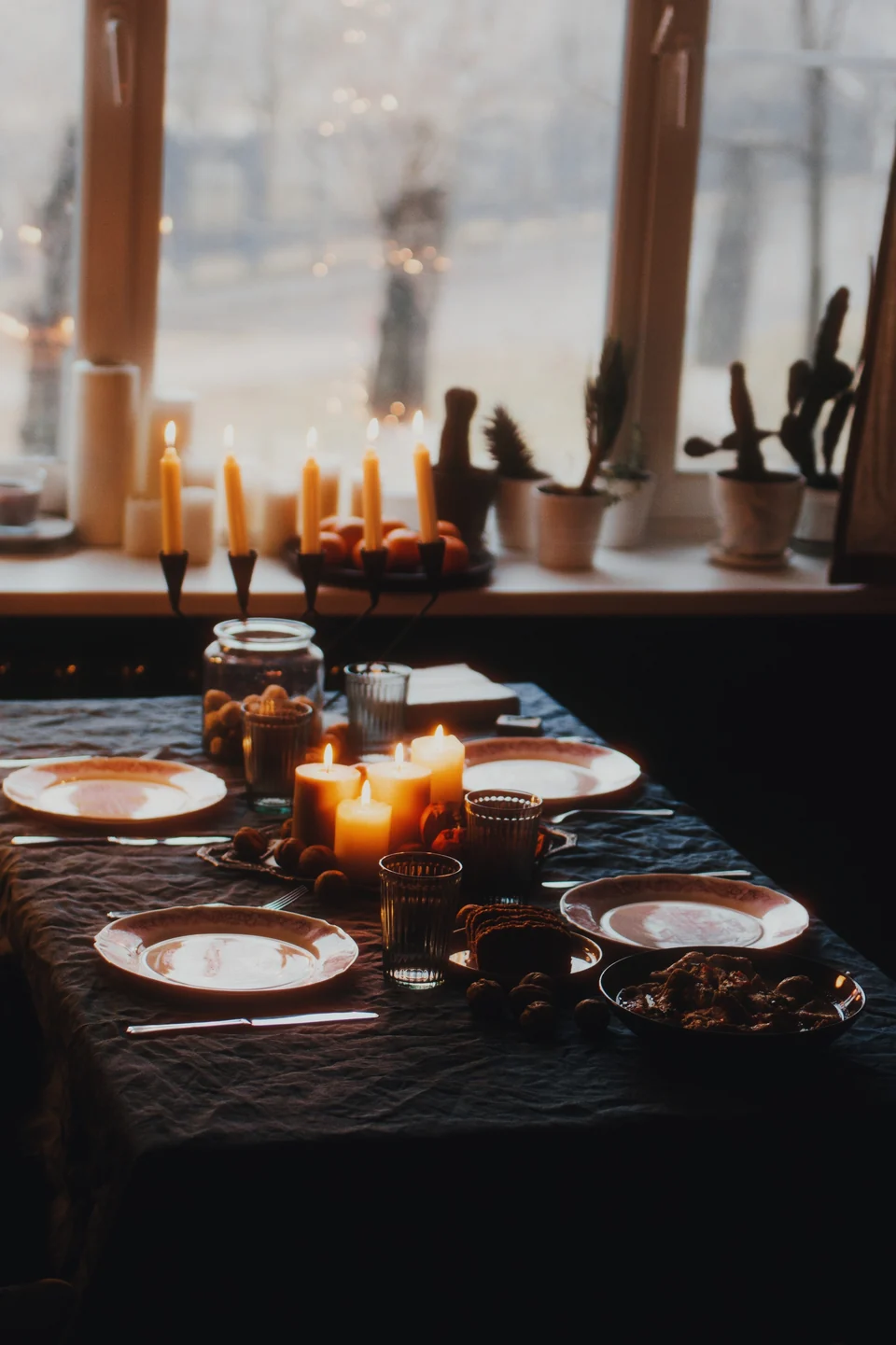 A dinner table with candles, glasses and flowers, with the Candlelight preset in Photonica