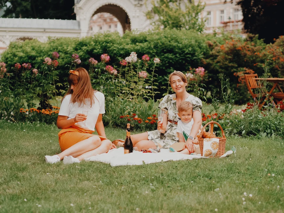 Friends sharing a picnic in a flower garden, with the Daylight preset in Photonica